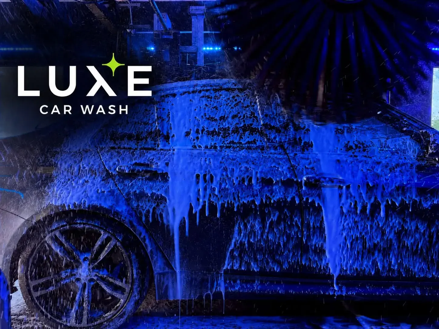 Car covered in foam inside the Luxe wash tunnel